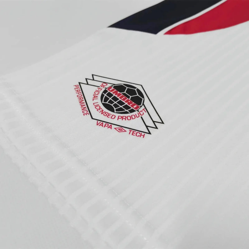 Close-up of a logo on a white England 1998 home kids kit with red, black, and blue accents.