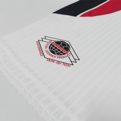 Close-up of a logo on a white England 1998 home kids kit with red, black, and blue accents.