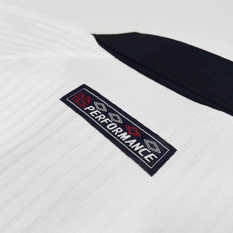 Close-up of a white England 1998 home kids kit with a 'PERFORMANCE' label on a light gray background