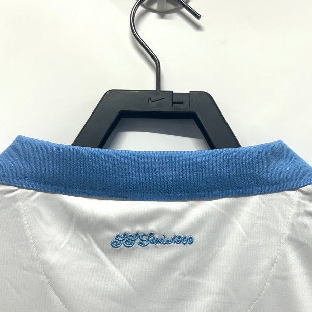 White Lazio 14/15 fourth shirt with blue collar on a hanger against a white background