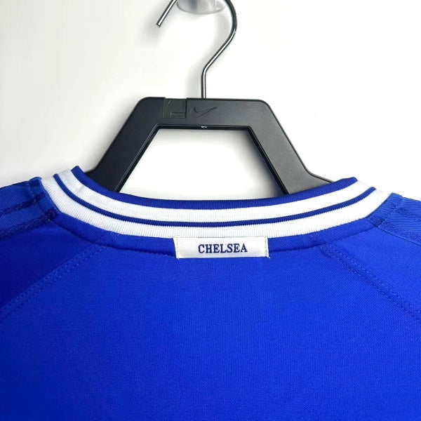 Blue Chelsea 99-01 home shirt with 'Chelsea' branding on a hanger against a white background