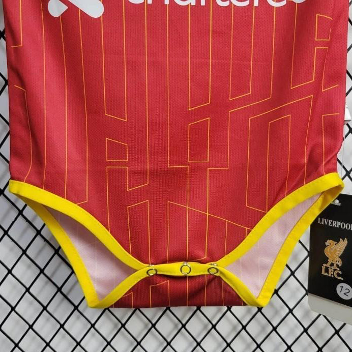 Red liverpool 24/25 home baby onesie with yellow trim on a checkered background, featuring Liverpool FC branding.