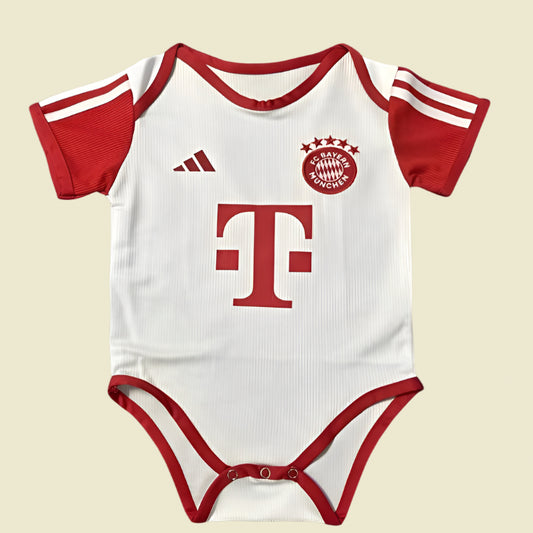 White and red Bayern Munich 23/24 home baby onesie with sports team logos on a black background
