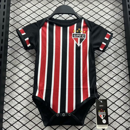 Black and red striped São Paulo 2024 away baby onesie  with SPFC logo on a hanger against a grid background