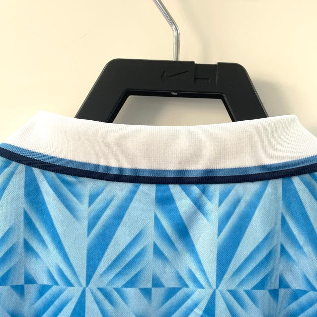 Blue and white patterned Lazio 91/92 home shirt on a hanger with a neutral background