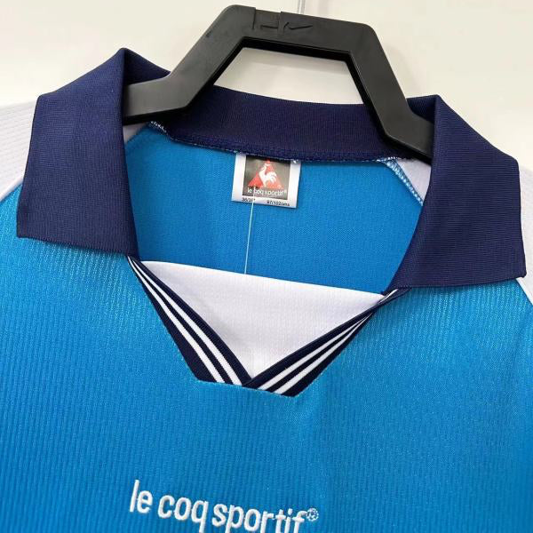 Blue Man City 99-01 home shirt with navy collar on a hanger against a white background
