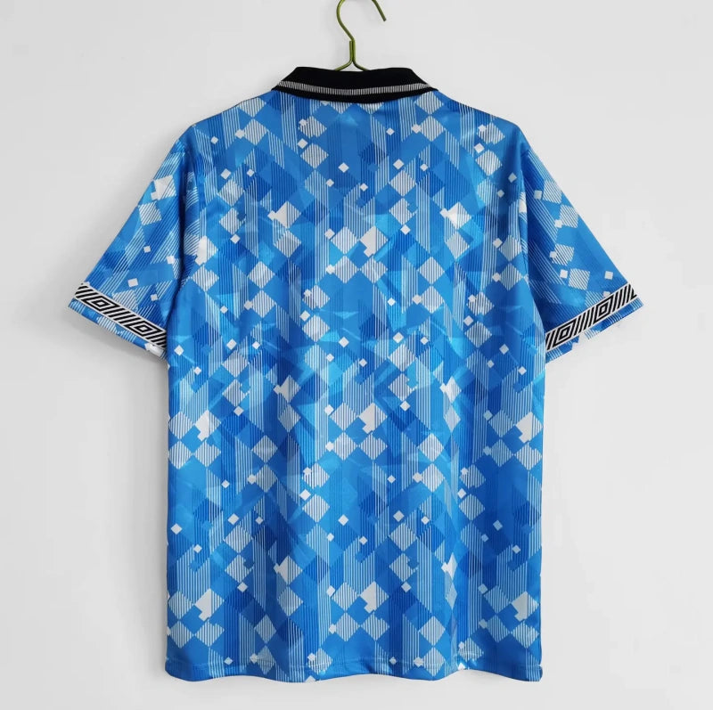 Blue patterned England 1990 third shirt on a hanger against a white background
