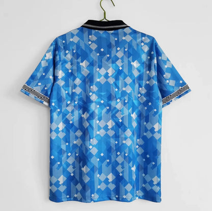 Blue patterned England 1990 third shirt on a hanger against a white background