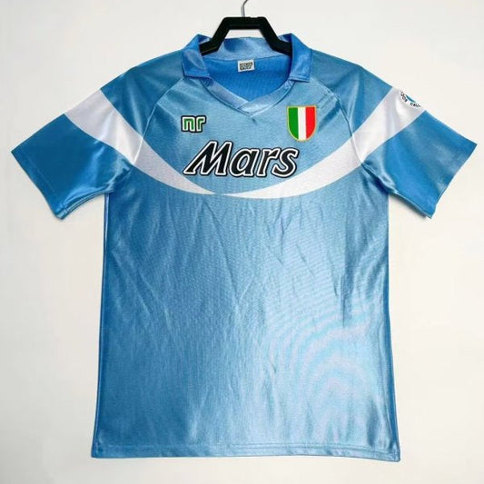 Blue Napoli 90/91 home 2nd shirt with 'Mars' branding on a hanger against a white background