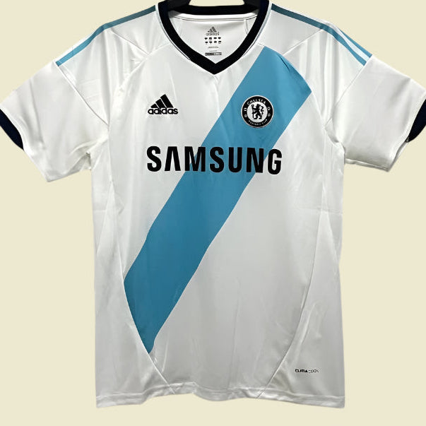 White Chelsea 12/13 away shirt with blue stripe, Adidas logo, and Samsung branding on a white background