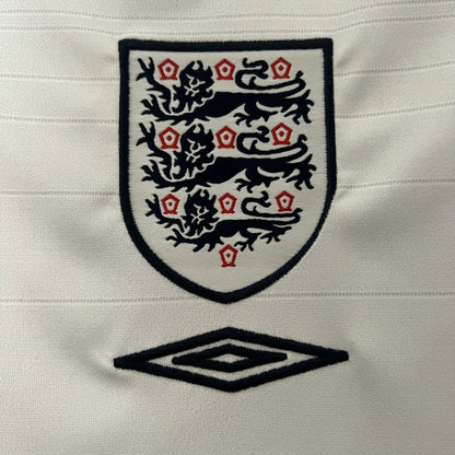 Embroidered logo of England on a England 2004 home shirt with Umbro logo below.