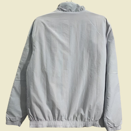 Light gray Ac Milan 2010’s windbreaker jacket  on a hanger against a plain background